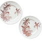 Two round ceramic plates with a brown tropical dragonfly and palm tree pattern on a cream background, arranged on a rustic dark wood plank surface.