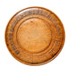 Round wooden object with engraved text on a light gray background