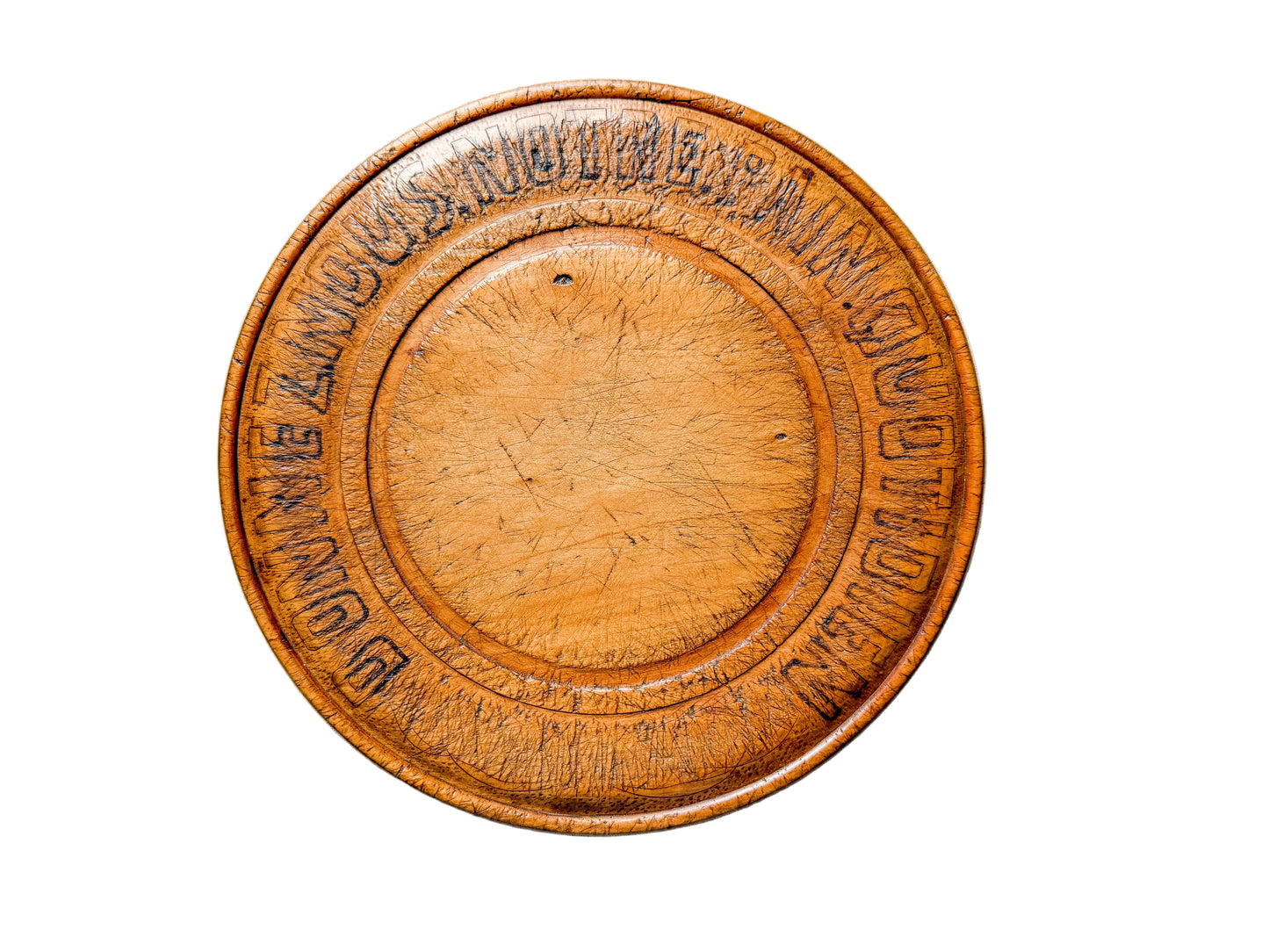 Round wooden object with engraved text on a light gray background