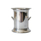 A polished silver metal bucket or ice bucket with side handles, standing on a white marble surface against a matching marble background.