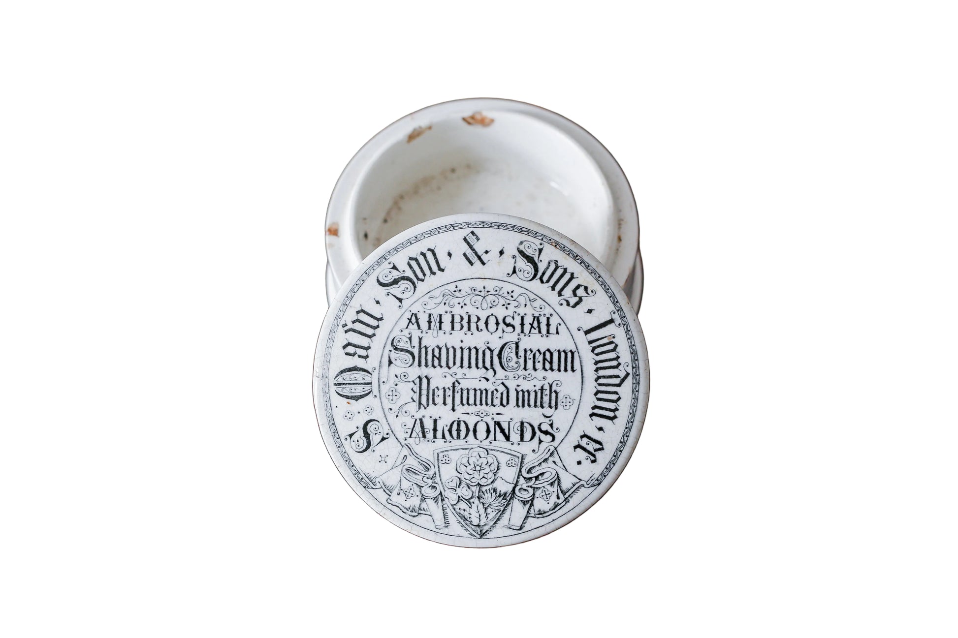 Vintage shaving cream container with a label on a wooden surface