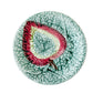 Decorative plate with a leaf design on a textured beige surface