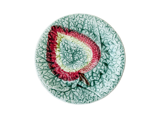 Decorative plate with a leaf design on a textured beige surface