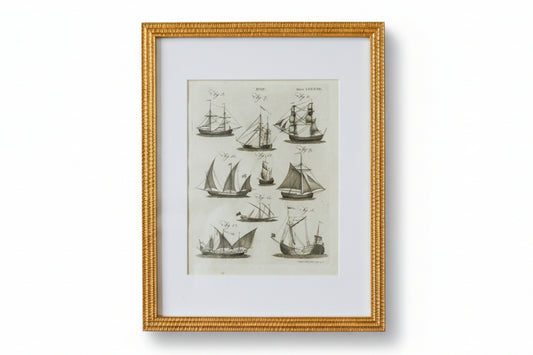 Framed artwork of vintage ship illustrations on a textured wall.