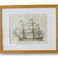 Framed black and white ship print on a textured wall