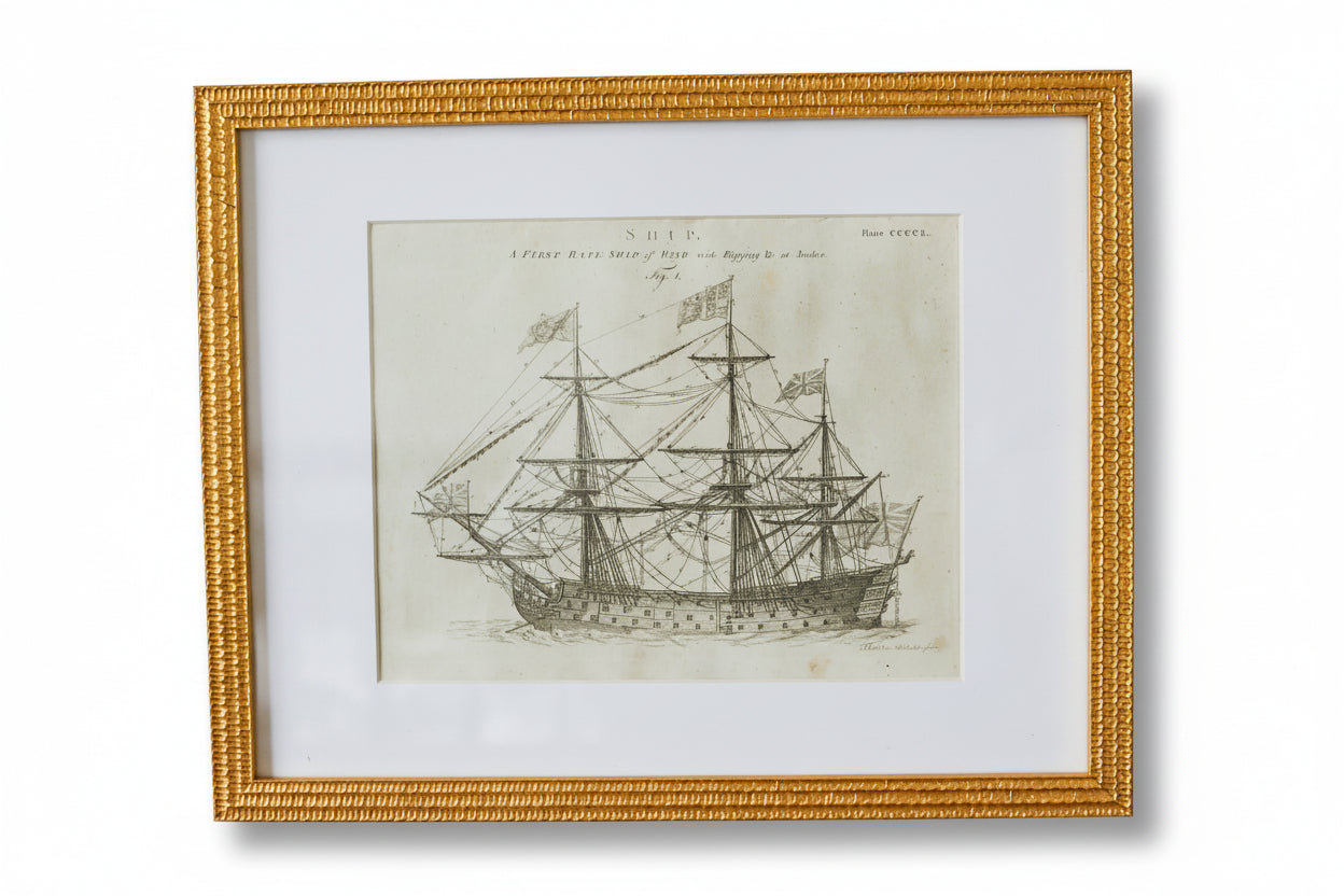 Framed black and white ship print on a textured wall