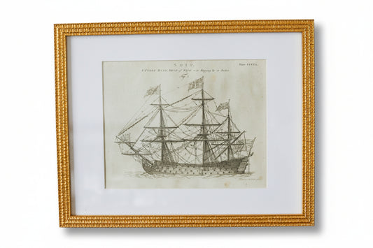 Framed black and white ship print on a textured wall