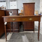 Edwardian ochre leather topped writing desk with two drawers and caster wheels
