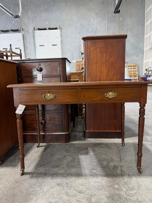 Edwardian ochre leather topped writing desk with two drawers and caster wheels