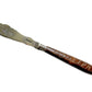 Vintage knife with a decorative handle on a textured gray surface