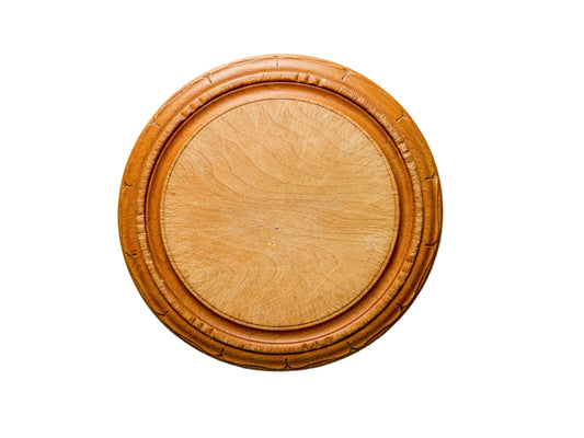 Round wooden coaster on a light gray textured surface