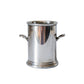 A small polished silver metal pot with side handles, standing on a white marble surface against a matching marble background.