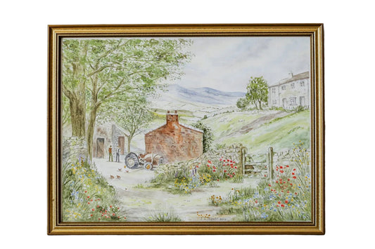 Framed painting of a countryside scene on a textured wall.