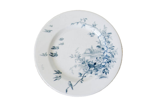 White plate with blue floral design on a textured beige surface