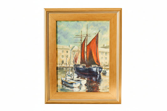 Framed painting of a sailboat in harbor in gold tone frame