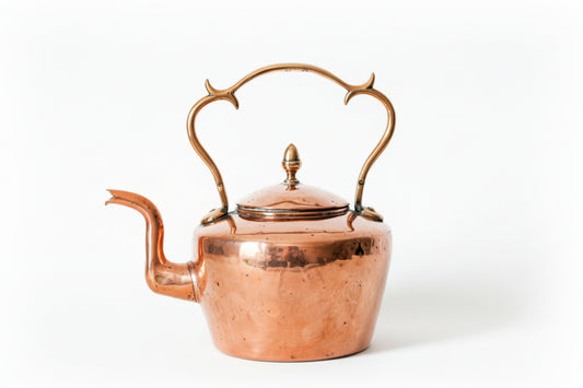 Copper teapot with decorative handles on a white background