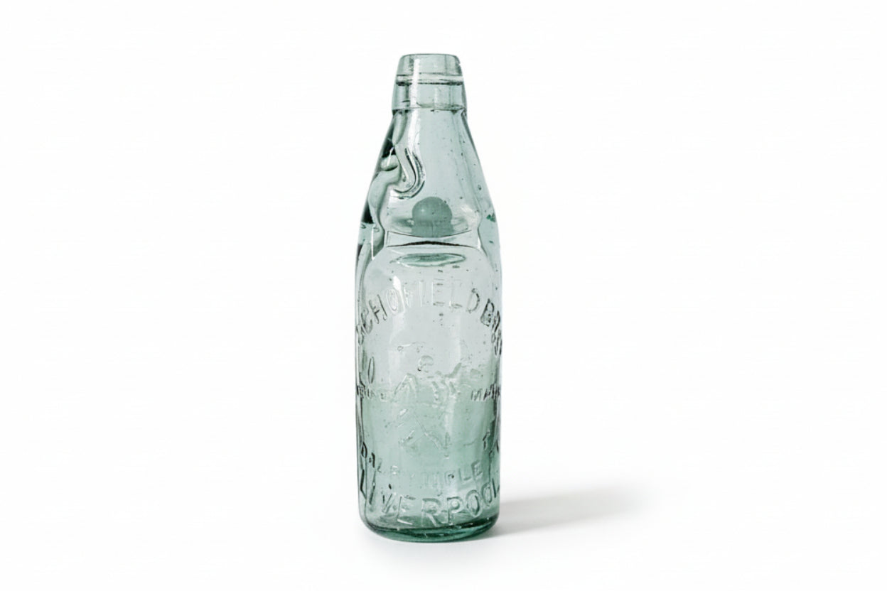 Vintage green glass bottle on a textured white surface