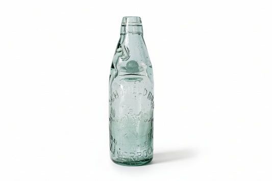 Vintage green glass bottle on a textured white surface