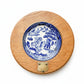 Blue and white ceramic plate with a wooden frame on a textured white background