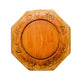 Wooden decorative plate with carvings on a light wooden surface