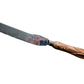 A vintage wooden-handled knife with a dark metal blade, featuring a carved wood handle and a red painted section near the base of the blade, displayed on a textured off-white fabric background.
