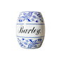 Ceramic jar with blue floral patterns and the word 'Barley' on a textured surface.