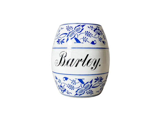 Ceramic jar with blue floral patterns and the word 'Barley' on a textured surface.