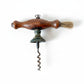 Vintage corkscrew with wooden handle on a textured fabric background