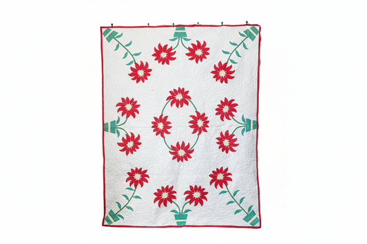 Floral quilt with red flowers and green leaves on a white background