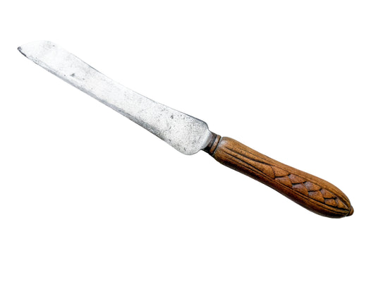 Vintage bread knife with a wooden handle on a textured white background